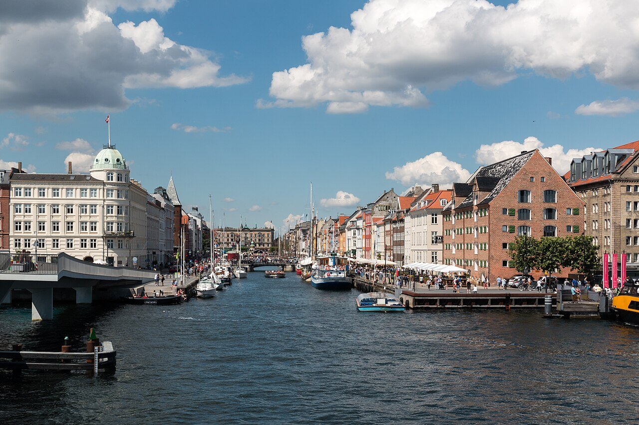 Nyhavn harbour in Copenhagen with boats and colorful townhouses on a summer day