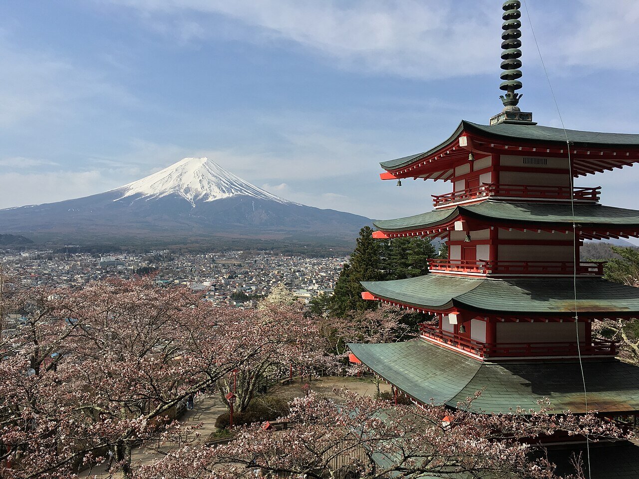 Chureito Pagoda with cherry blossoms and snow-capped Mount Fuji in the distance
